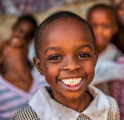 Group of colorful dressed, happy African children, orphanage in Kenya. There is no light and electricity inside the classroom. Around 20-30 orphans live in this orphanage which is located near Nairobi.